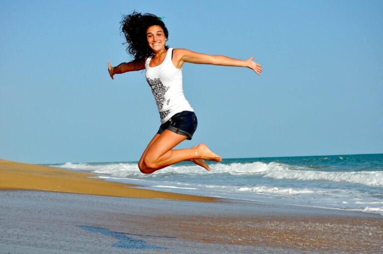 Glückliche Frau im Sprung am Strand