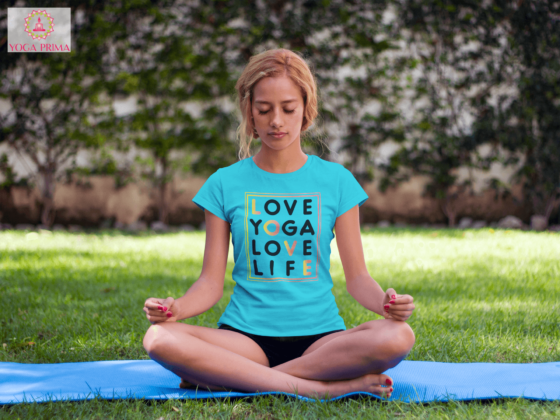 Junge Frau beim Yoga im Park mit unserem Love Yoga Love Life Shirt in Karibikblau