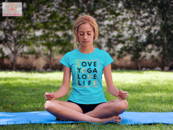 Junge Frau beim Yoga im Park mit unserem Love Yoga Love Life Shirt in Karibikblau