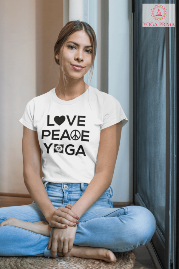 Junge Dame im Schneidersitz mit Jeans und unserem Love Peace Yoga T-Shirt in Weiß Alltag