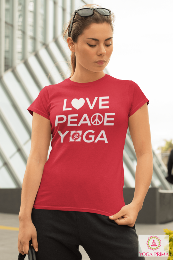 Junge Frau mit Handtasche vor Gebäude im Sommer mit rotem Love Peace Yoga T-Shirt